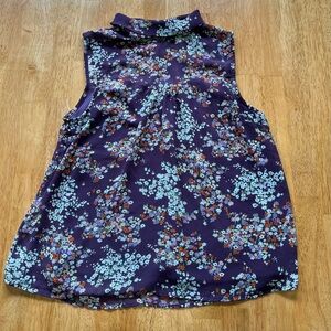 Women’s sleeveless floral blouse with roll neck detail